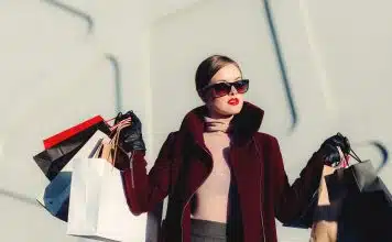 photo of woman holding white and black paper bags